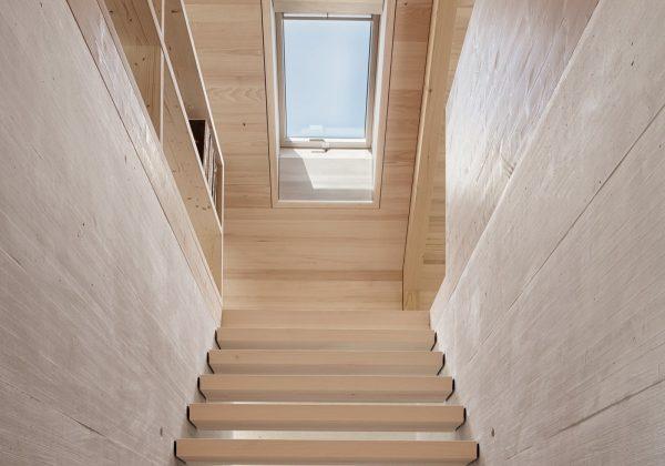 Scala moderna in legno illuminata da una finestra per tetti