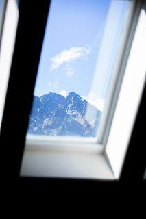 finestra per tetti VELUX dalla quale si vede una montagna rocciosa innevata