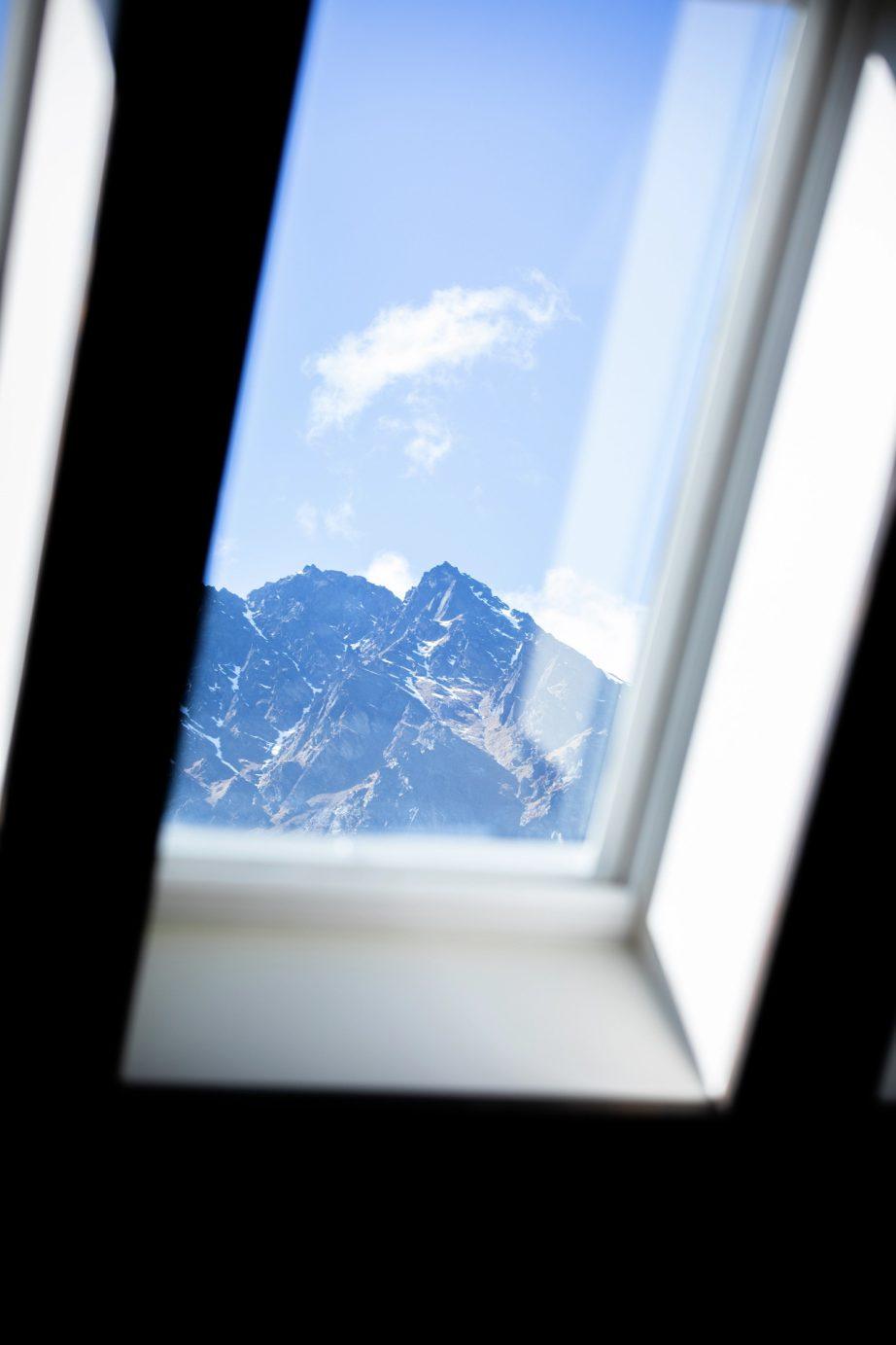 finestra per tetti VELUX dalla quale si vede una montagna rocciosa innevata