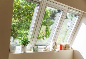 mansarda con tre finestre VELUX affiancate e l'esterno con molte piante verdi mansarda con tre finestre VELUX affiancate e l'esterno con molte piante verdi